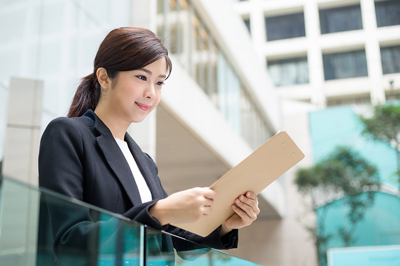 A cheerful woman standing outside the office, symbolizing positivity and teamwork, related to severance pay in South Korea