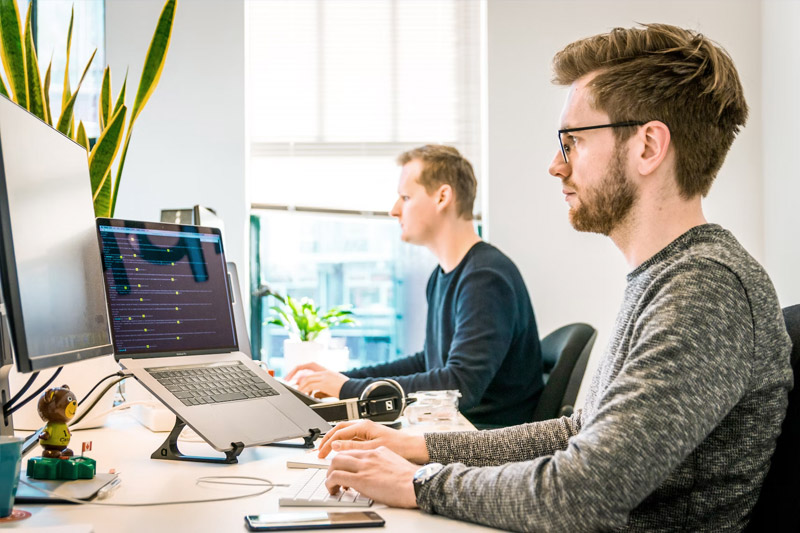 Two people working in an office, representing the topic of severance pay in Austria and employer responsibilities