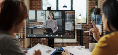Two people in a video call with another person, representing Asian business people interviewing a remote recruiter
