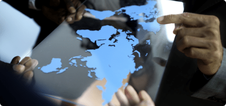 Several people holding a world map, symbolizing business team global business planning working together