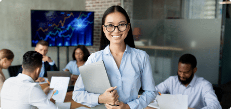 Smiling employee posing in an office with a team working in the background, representing a recruitment agency in China and hiring in China